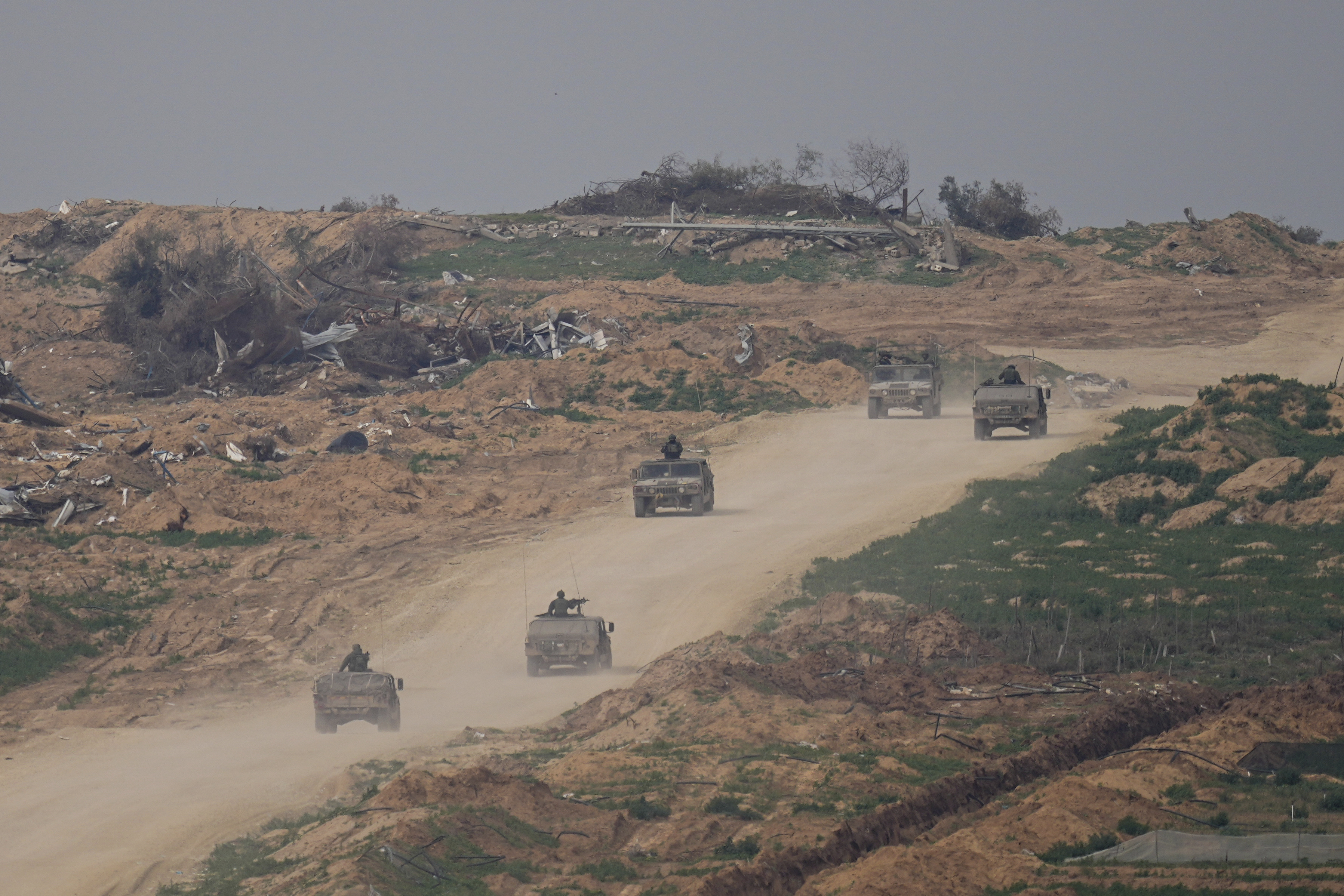 Israeli army vehicles move in the Gaza Strip near the Israeli-Gaza border as seen from southern Israel, Wednesday, Jan. 17, 2024.(AP Photo/Ohad Zwigenberg)